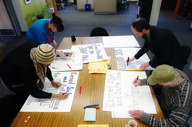 TakeAction Minnesota volunteers create signs about equal pay issues