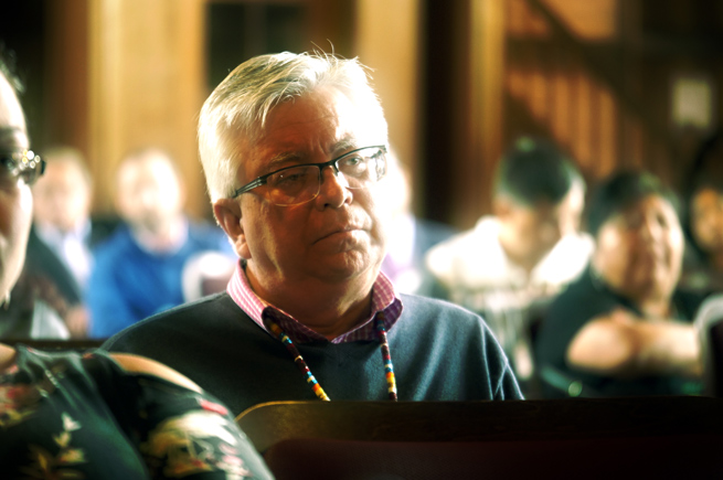 Man listening to a speaker at an Oweesta convening