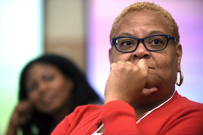 A woman listens to a speaker at an event