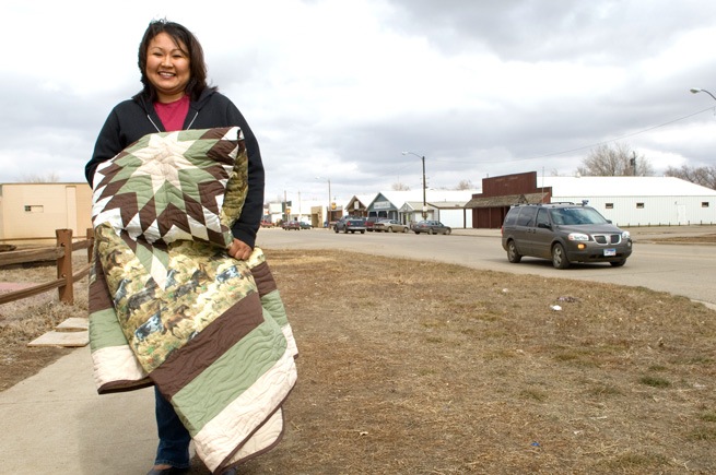 Native American woman holding a quilt in Eagle Butte, South Dakota