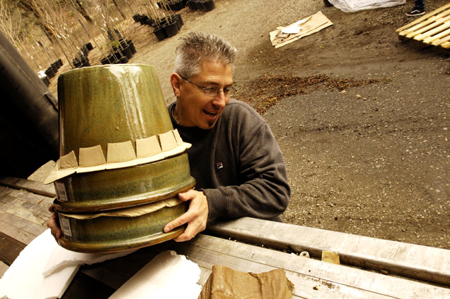 Man transporting ceramic planters to a palette