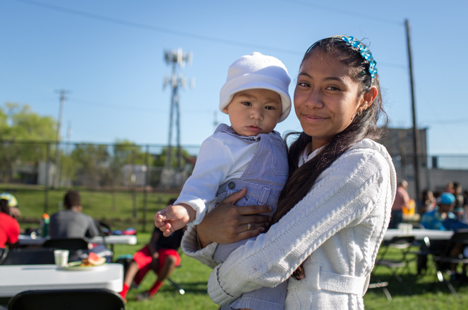 Teenage Latina girl holding a young child at an Urban Ventures’ Summer Ventures Learning Lab program