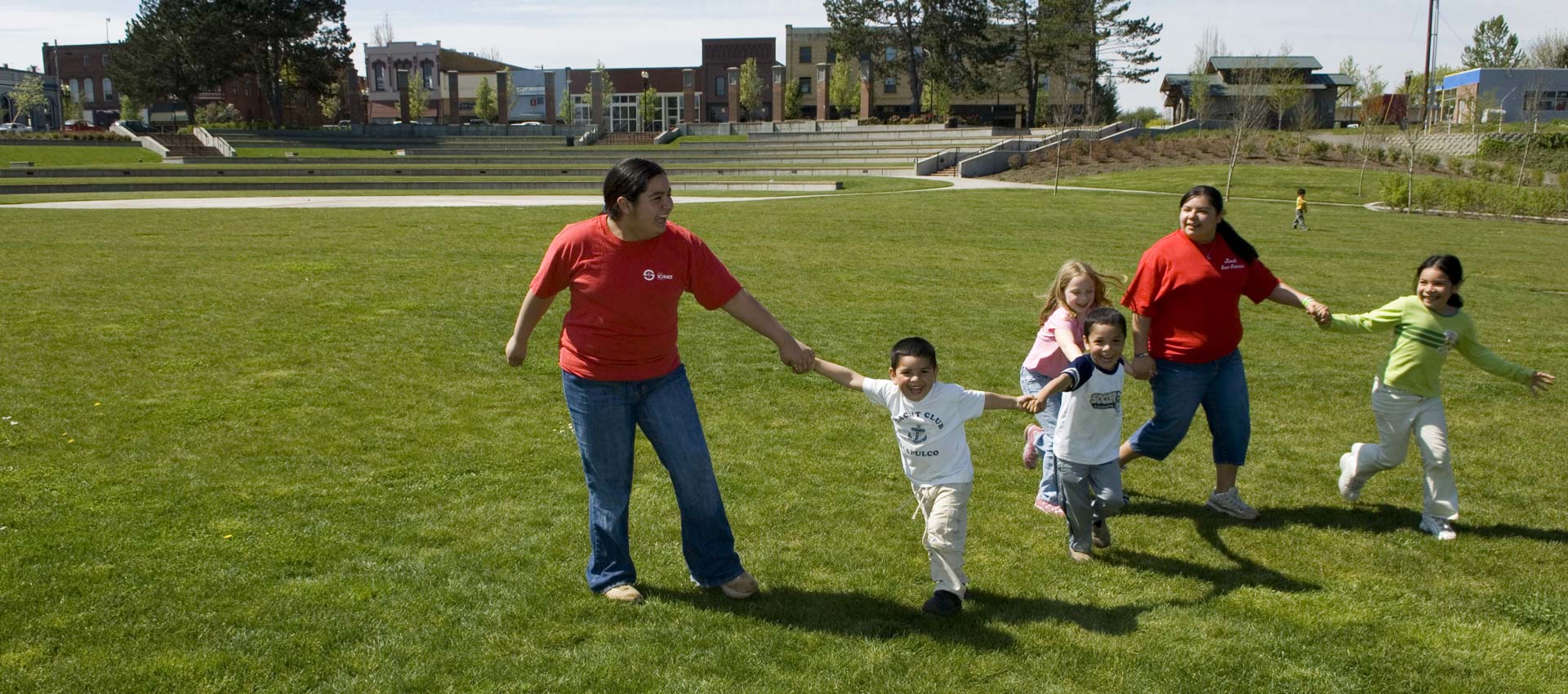 Group of youth with adults laughing and playing outside