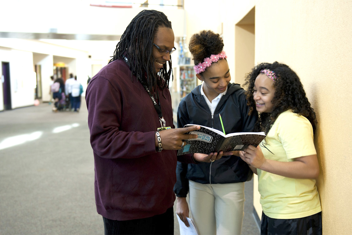 Teacher and students engaged a in school hallway